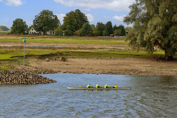 Dutch countryside, group of people rowing in the stream