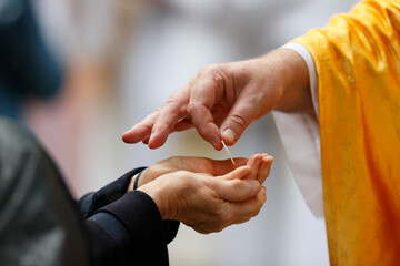 Catholic Mass. Priest giving Communion. Host symbolizing the body of Christ. La Roche sur Foron..  France.