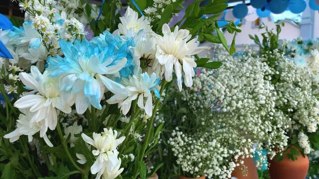 white flowers painted blue in vases. flowers in the sea for Yemanj&aacute; queen of the sea. 