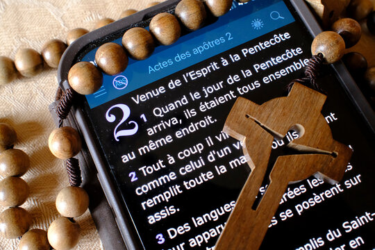 Rosary and digital bible on a smartphone. New testament.  Pentecost.