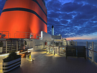 Breathtaking sunset night time twilight ocean view from outdoor teak promenade deck of ocean liner...