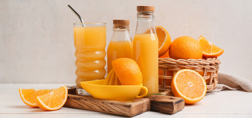 Composition with fresh orange juice and fruit on light background