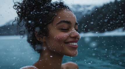 Obraz premium Joyful woman enjoying snowfall by serene winter lake. Cold Plunge. Winter ice bath, cold bath. Snow swimming, cold water therapy