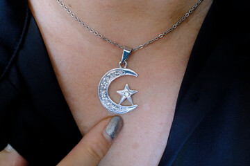 Woman wearing muslim jewelry with crescent and star. Symbol of Islam.
