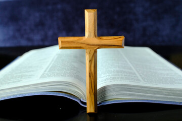 Open Holy bible with a christian cross. Symbol of Christianity.