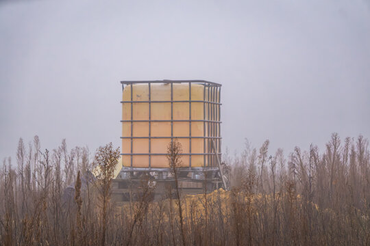 Mauser with water at a warehouse construction site on a foggy morning.