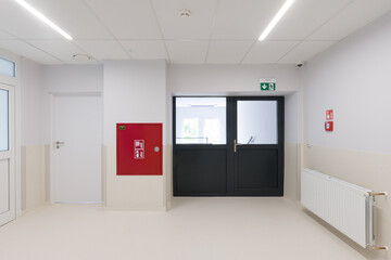 Modern Hallway with Multiple Doors and Fire Safety Equipment
