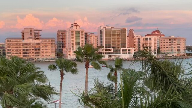 Downtown Sarasota Florida with Golden Gate Point from John Ringling Causeway bridge, yachts, palms and hotels, pink skies during beautiful Florida sunset