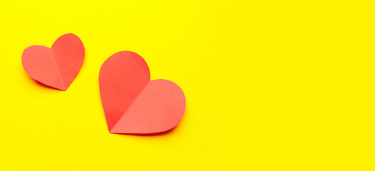 Red paper hearts on yellow background. Valentine's Day celebration