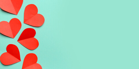 Red paper hearts on turquoise background. Valentine's Day celebration