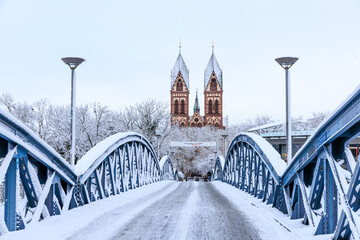 Schneebedeckte Herz-Jesu-Kirche und Wisili-Brücke in Freiburg, Baden-Württemberg, Deutschland