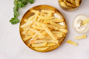 Plate of tasty french fries with sauce on white background