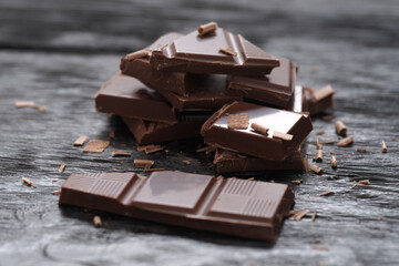 Broken dark chocolate on a wooden table