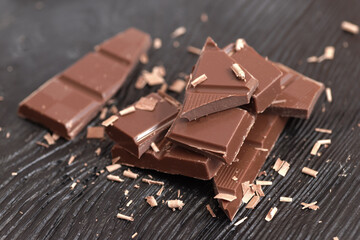 Broken dark chocolate on a wooden table