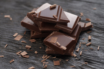 Broken dark chocolate on a wooden table