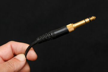 Naklejka premium jack plug audio cable isolated on dark background