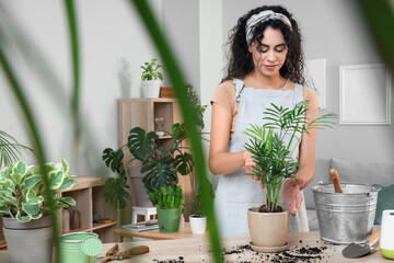 Female African-American gardener transplanting plant at home