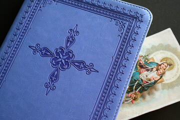 Blue Bible with a religious image. Virgin Mary and child.