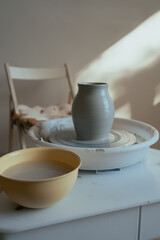 working place in pottery studio, tools for making ceramic and just formed wet clay vase