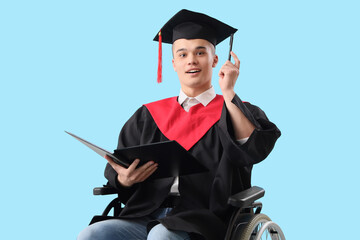 Male graduate in wheelchair with folder on blue background