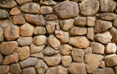 Brown embossed pebble wall for abstract background and texture for interior or exterior design. Beautiful patterns, space for work, banner, wallpaper close up.