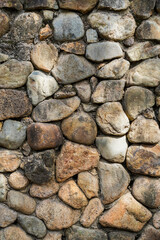 Embossed pebble wall for abstract background and texture for interior or exterior design. Beautiful patterns, space for work, banner, wallpaper close up.Vertical.