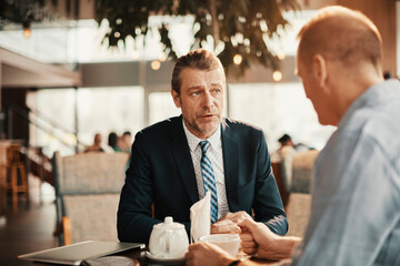 Business professionals having a meeting over coffee in a modern cafe