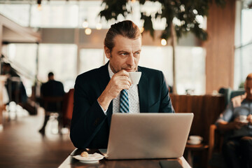 Professional businessman enjoying coffee while sitting in a modern cafe