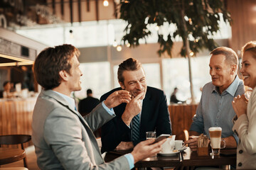 Diverse business people having meeting in modern cafe