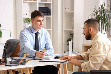 Young lawyer working with client in wheelchair at office