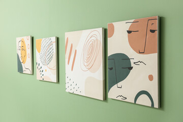Beautiful paintings hanging on green wall
