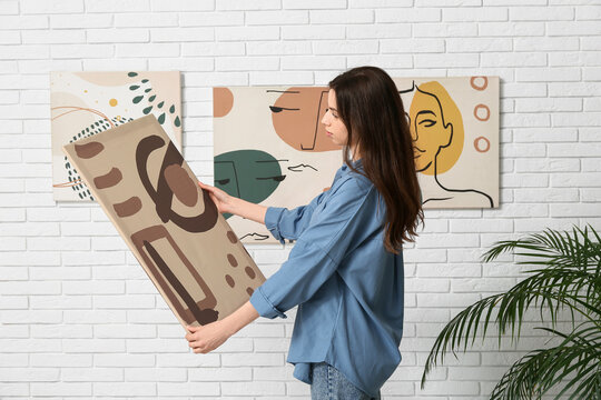 Young woman with painting at art gallery exhibition