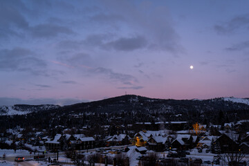 Night sky with full moon over winter village