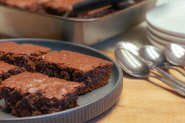 Plates, spoons, and brownies on the kitchen counter.