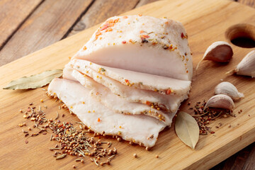 Salted lard with spices on a cutting board.