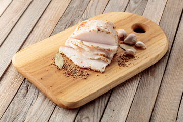 Salted lard with spices on a cutting board.