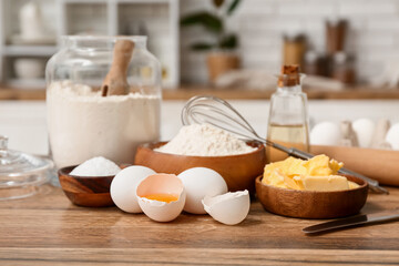 Flour in jar with eggs, butter and rolling pin for preparing dough on kitchen counter