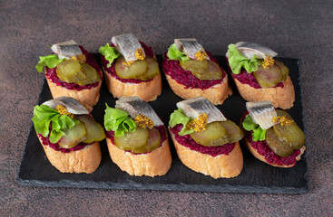 Bruschetta with herring, beetroot and pickled cucumber