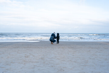 Dad and son in jackets in winter at the sea. High quality photo