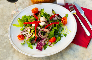 Bright vegetable salad with mini mozzarella, mix of salads, onion, cherry tomato, pepper