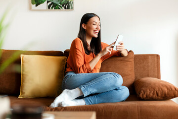 Excited woman reading message on cellphone, getting good news and smiling, chatting on Internet,...
