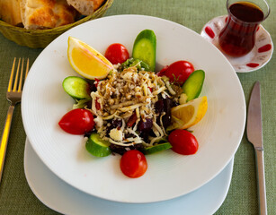 Just cooked Turkish salad served on table in restaurant. Dish made of fresh vegetables as starter.
