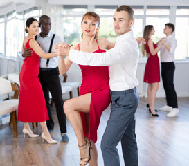 With unhurried music, guy and woman in couple spins to rhythm of rumba during lesson for novice...