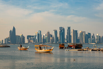 Wooden tour ships at seaside in Doha Qatar and cityscape with skyscrapers in the background