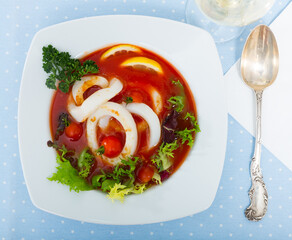 Dish of Mediterranean cuisine - tomato soup with squid and greens