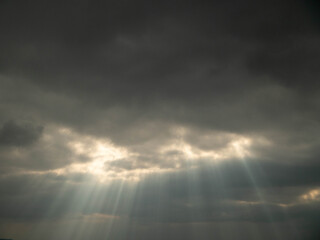Dramatic dark sky with god lights shining through. Nature abstract background.