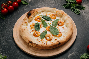 Gourmet shrimp pizza topped with fresh spinach leaves on a golden crust served on a wooden platter