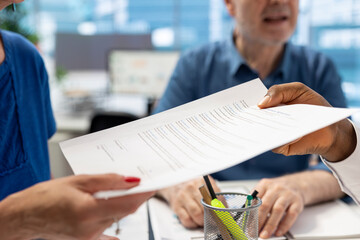 Financial planner giving the pension option contract to senior clients, providing a document with...