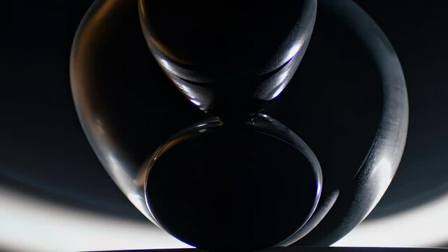 close-up of two curved black metallic objects forming a symmetrical shape against a gradient background, creating a mysterious and elegant visual