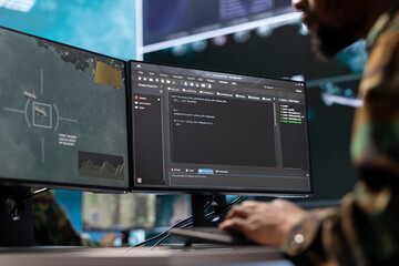IT analyst in a high tech base of operations handling surveillance activity and ensuring security protocols. Military command post crew collecting real time data to achieve mission objectives.